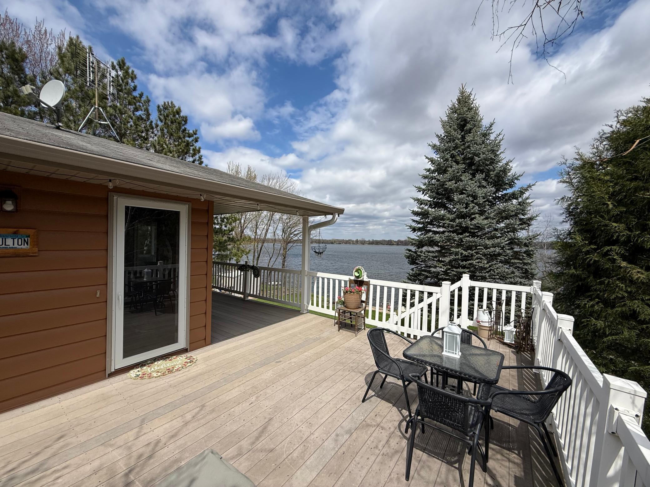 The wraparound deck has plenty of room for lakeside dining, cozy chairs, a gas fireside table, and peaceful views from every angle.