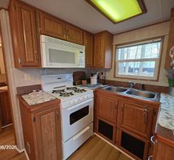 Kitchen has a full-sized stove, full-sized fridge and microwave, and plenty of storage for RV Life within the kitchen cabinets.
