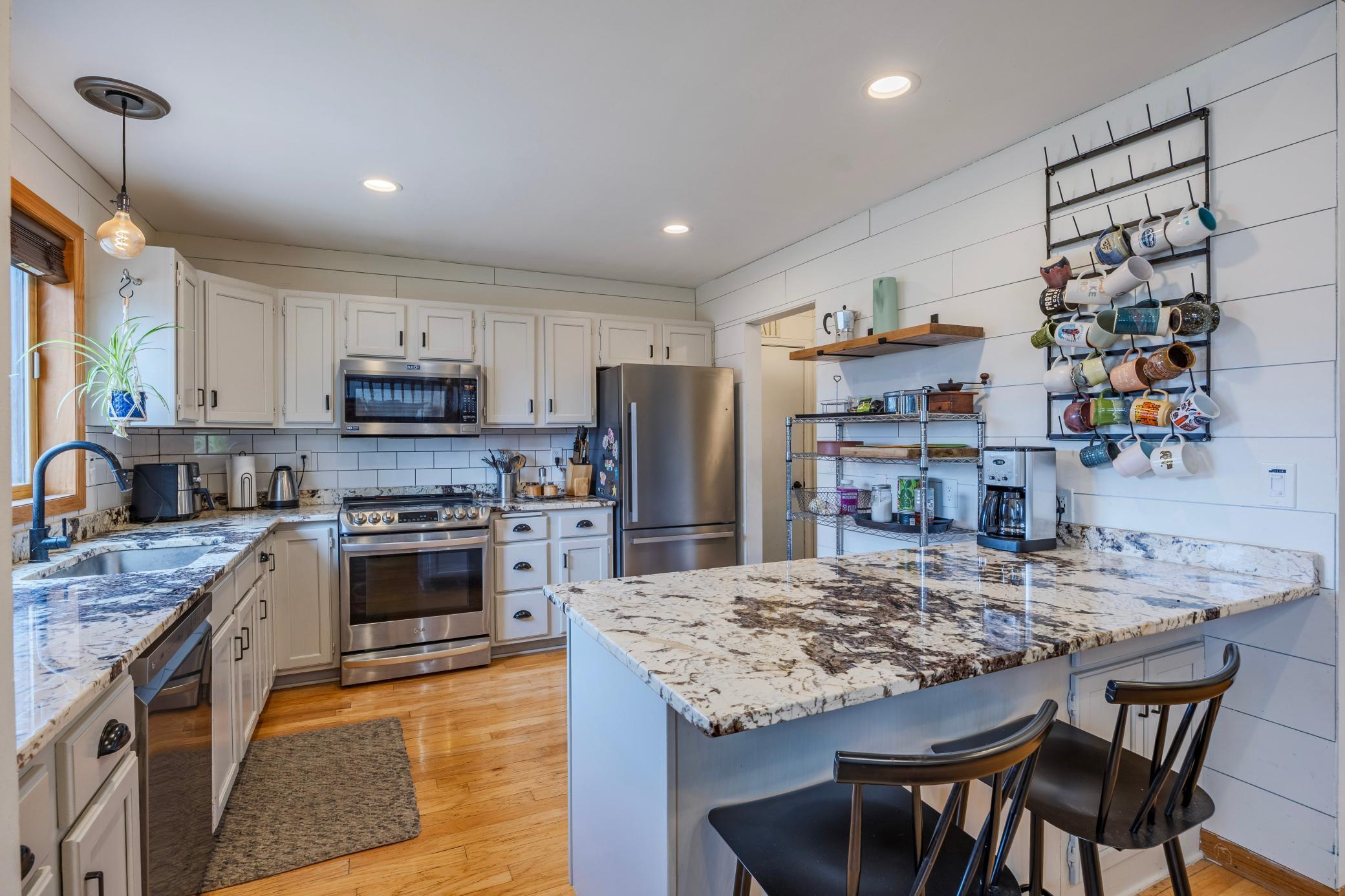 This light and bright kitchen has matching stainless appliances, a breakfast bar and granite countertops.