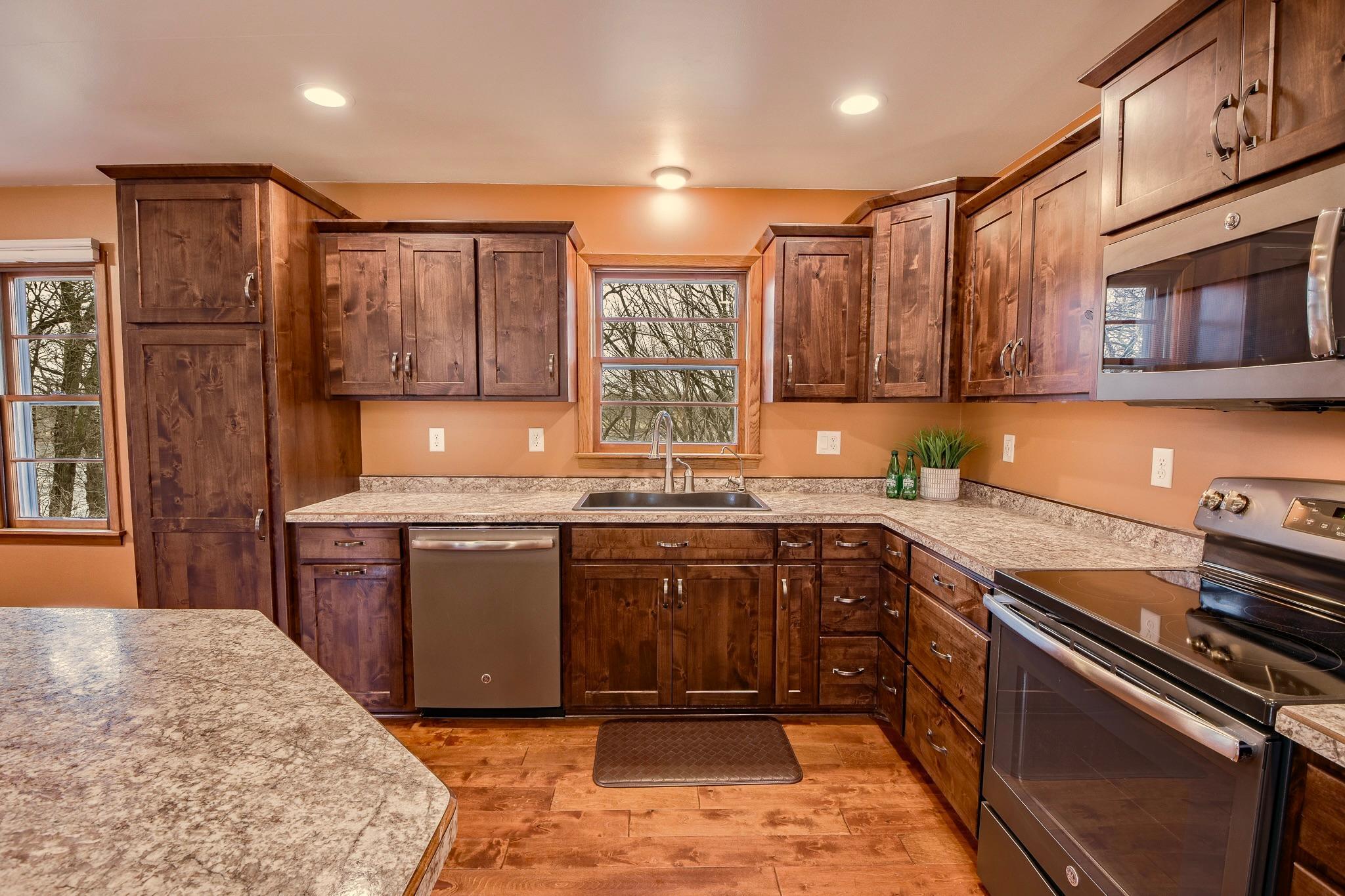 Kitchen showcases rich alder cabinetry, offering durability and timeless appeal.