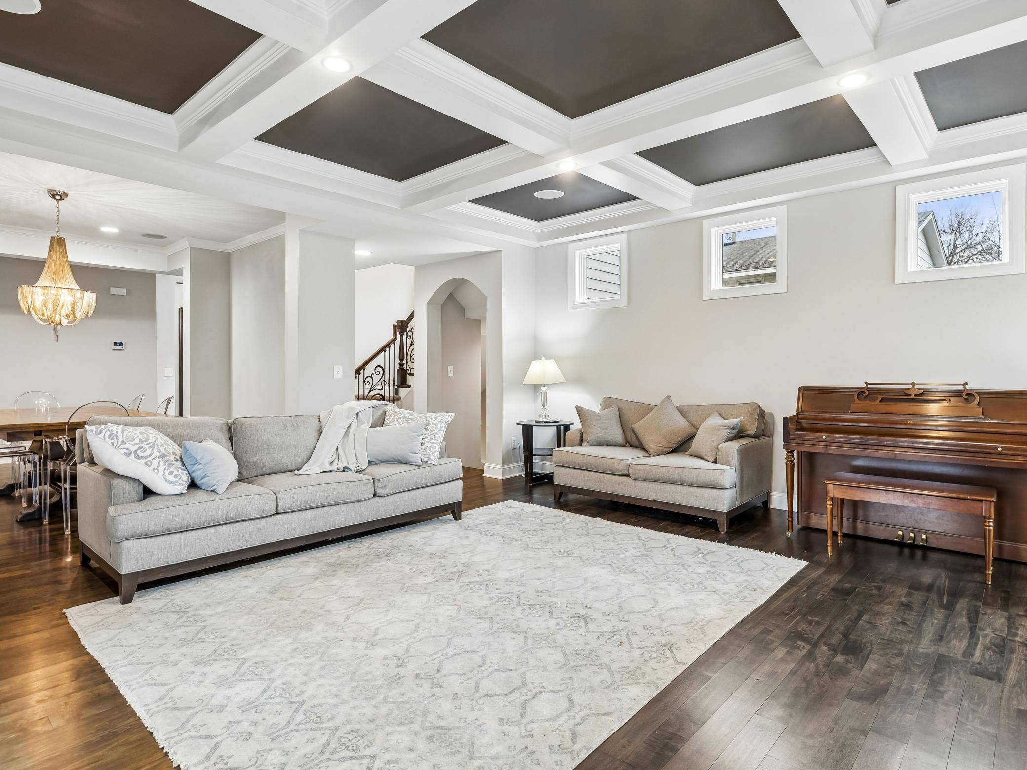 Roomy living room, perfect for gatherings. Door under archway leads to basement, stairs lead to upper level bedrooms