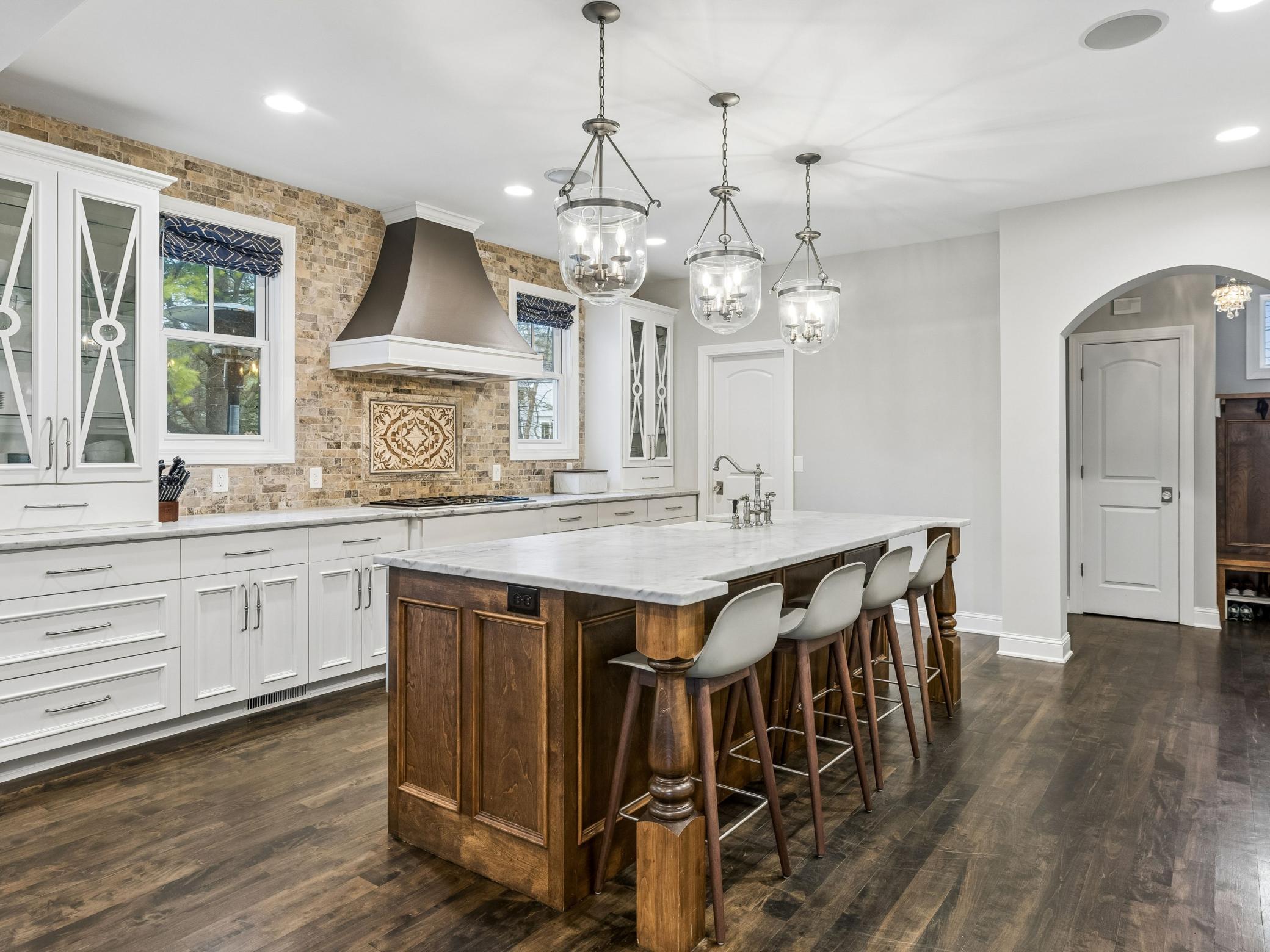 Substantial island perfect for cooking and hosting. Door on left leads to walk-in pantry, archway on the right leads to mud room and powder room.