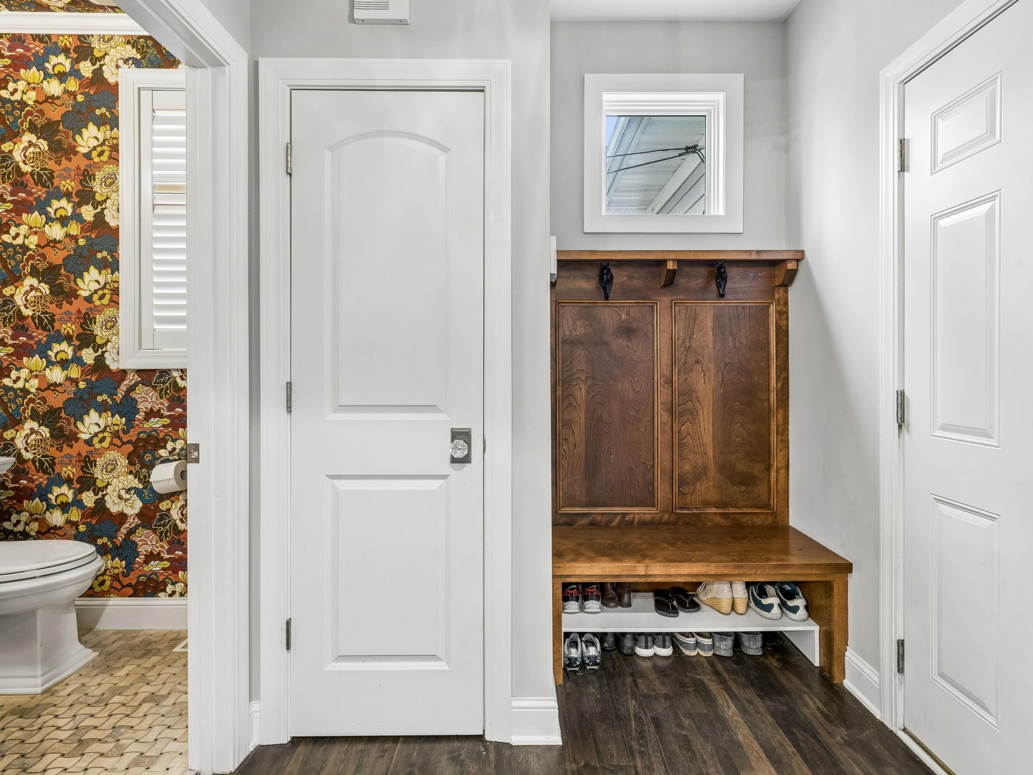 Mudroom off the attached garage, includes closet with the powder room to the left