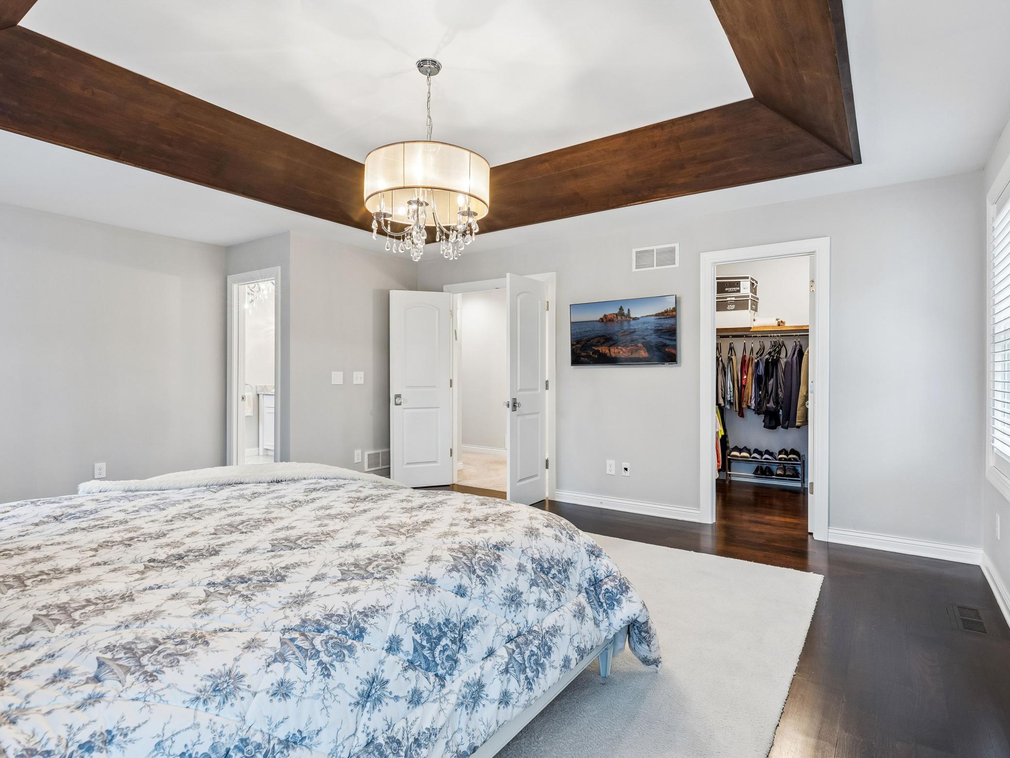Doorway to the left leads to the primary bathroom and second closet, door in the middle leads to the hallway and other bedrooms in the upper level, door on the right is second walk in closet in the primary