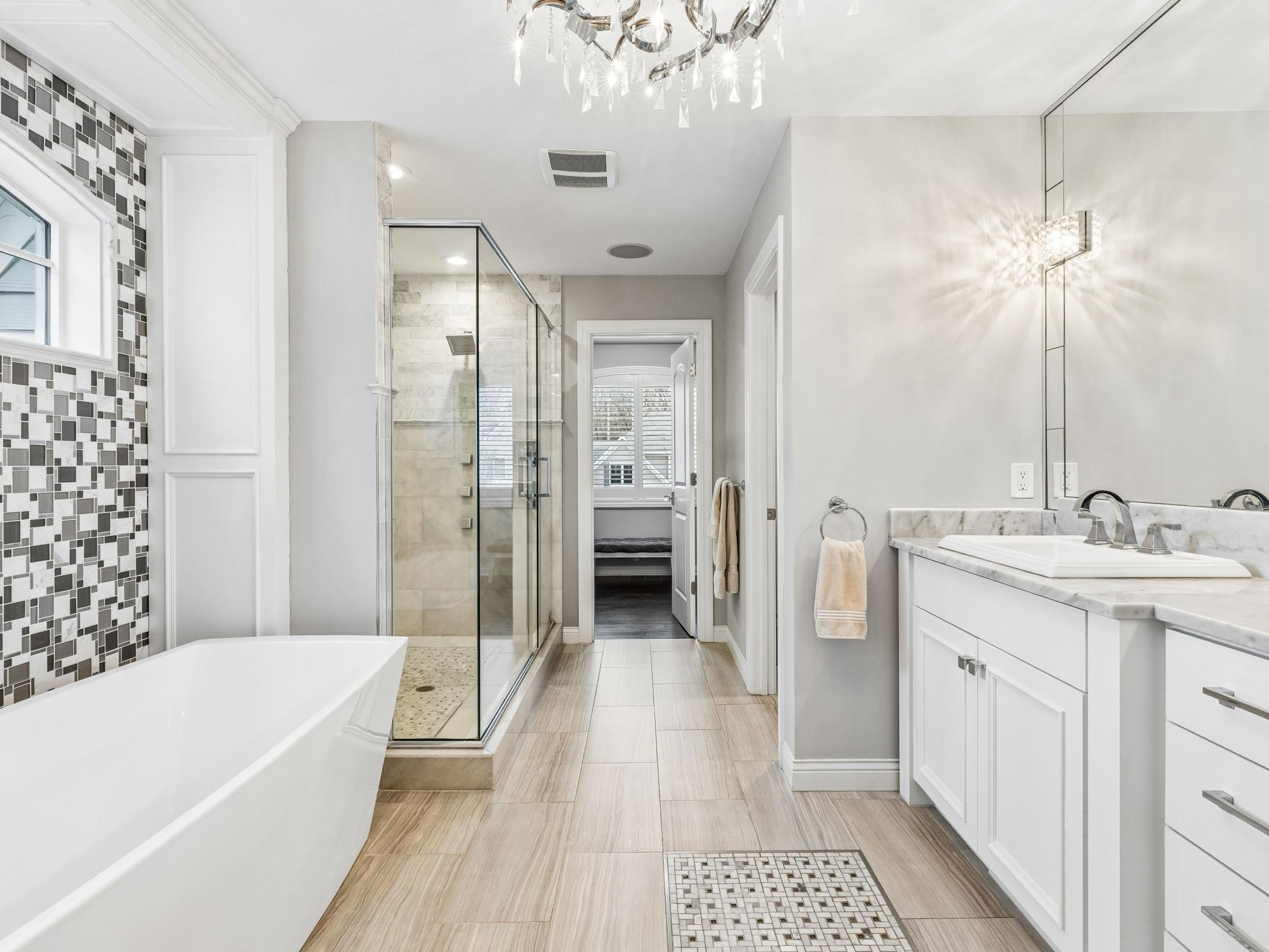 Sizable primary bathroom with the door at the end leading to the second walk-in closet in the primary suite