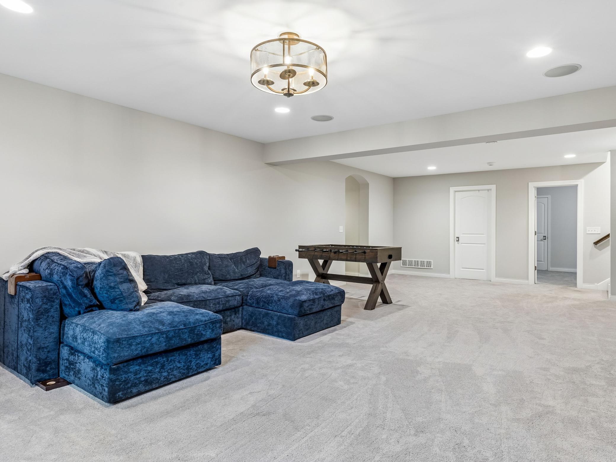 Oversized family room. Archway to the left leads to basement bathroom and bedroom. Door in the middle is the utility/storage room. Door on the right is the den