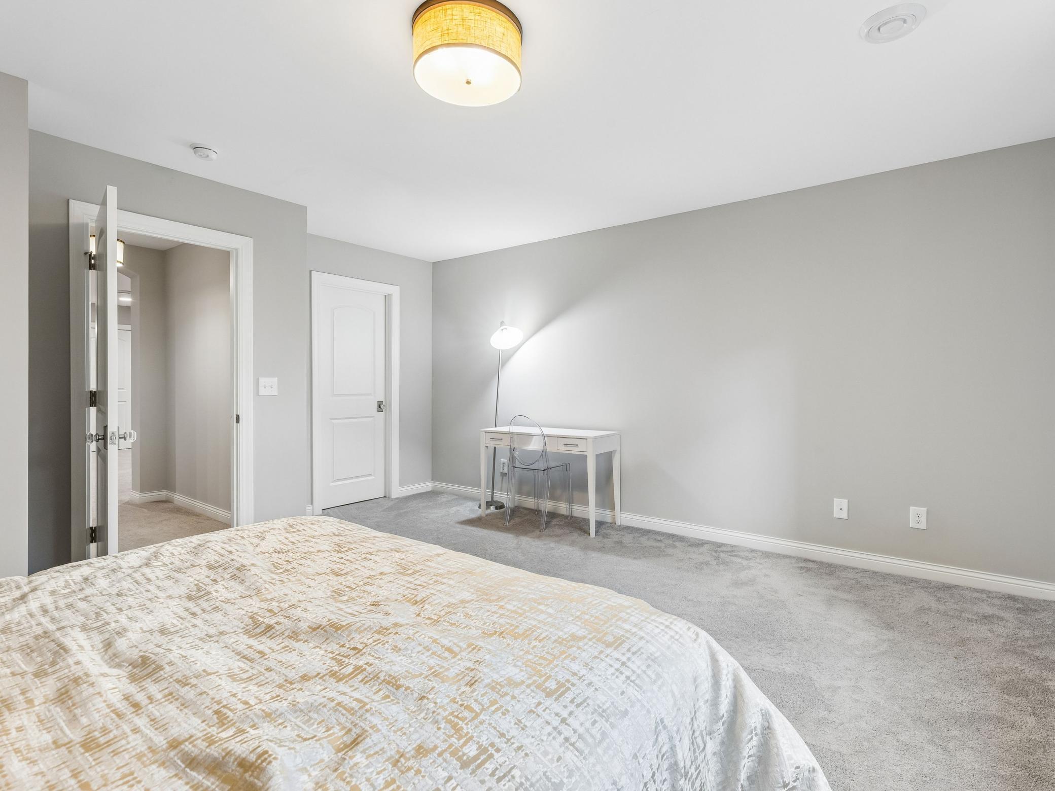 Spacious bedroom with enough space for a queen bed and a desk. Door on the left leads back to the family room, door on the right is a walk-in closet
