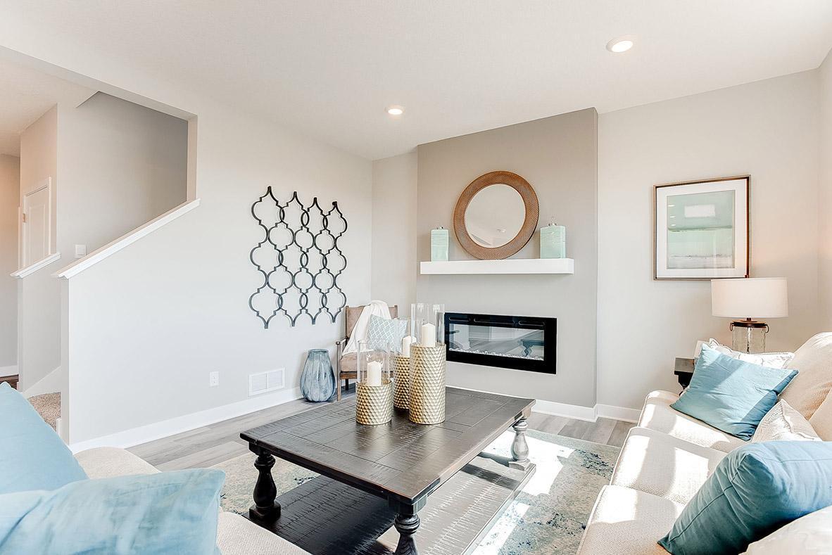 Living room with cozy electric fireplace and plenty of room for relaxing and entertaining. Model photo. Options and colors will vary.