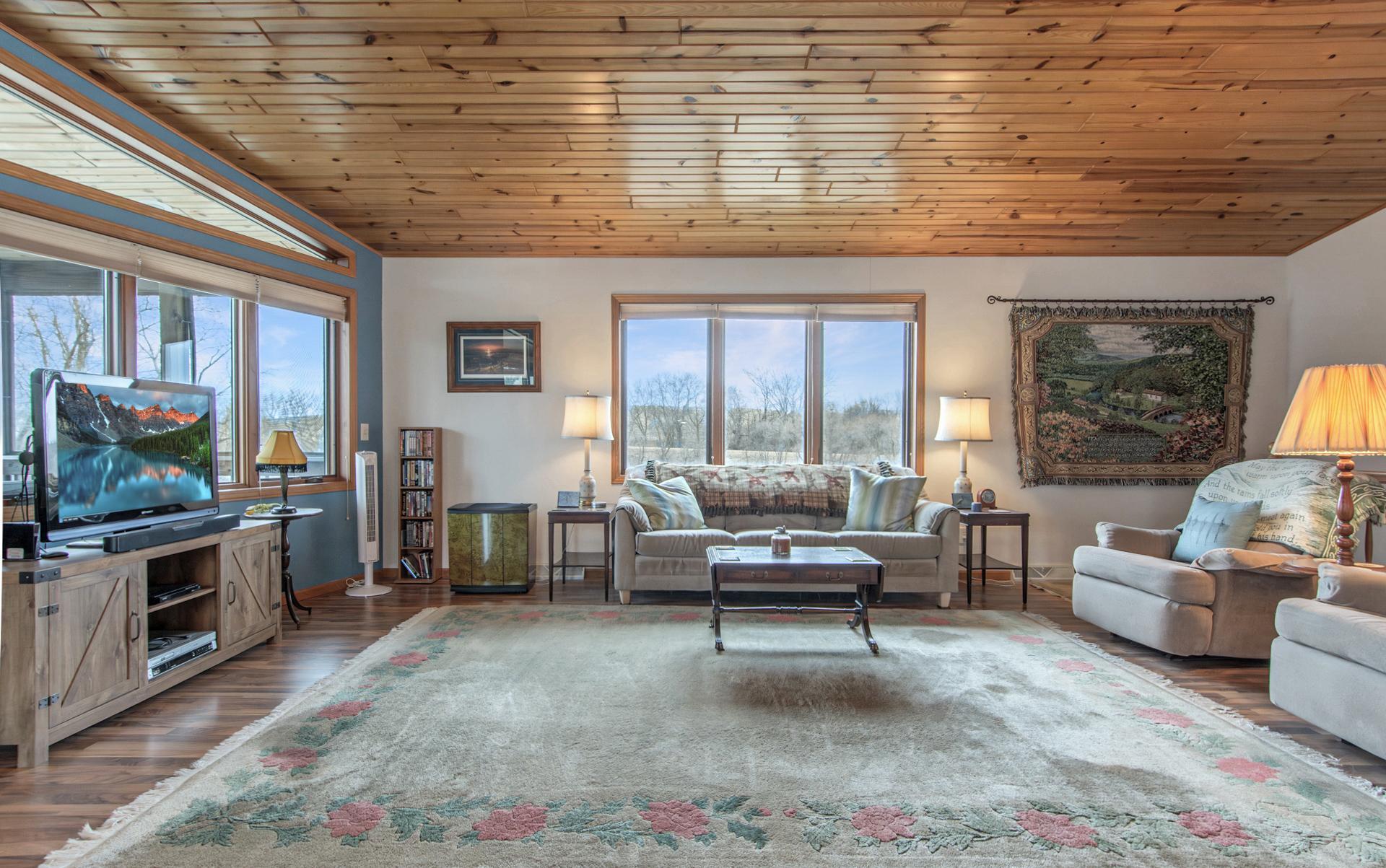 Seamless open-concept design connecting kitchen and living room, highlighted by vaulted ceilings and lake views.