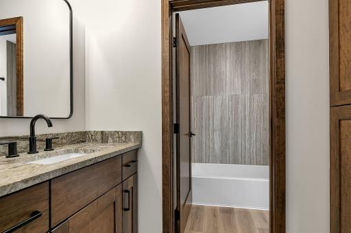 The full hall bath has the tub and stool separated from the granite topped vanity