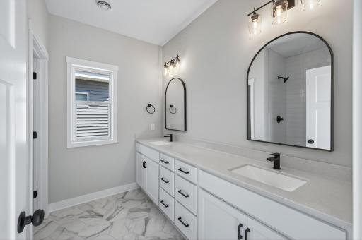 Beautiful primary bathroom with double sink vanity and lovely tiled shower