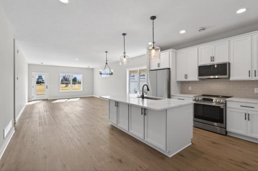 View of kitchen, dining room, and living room spaces.