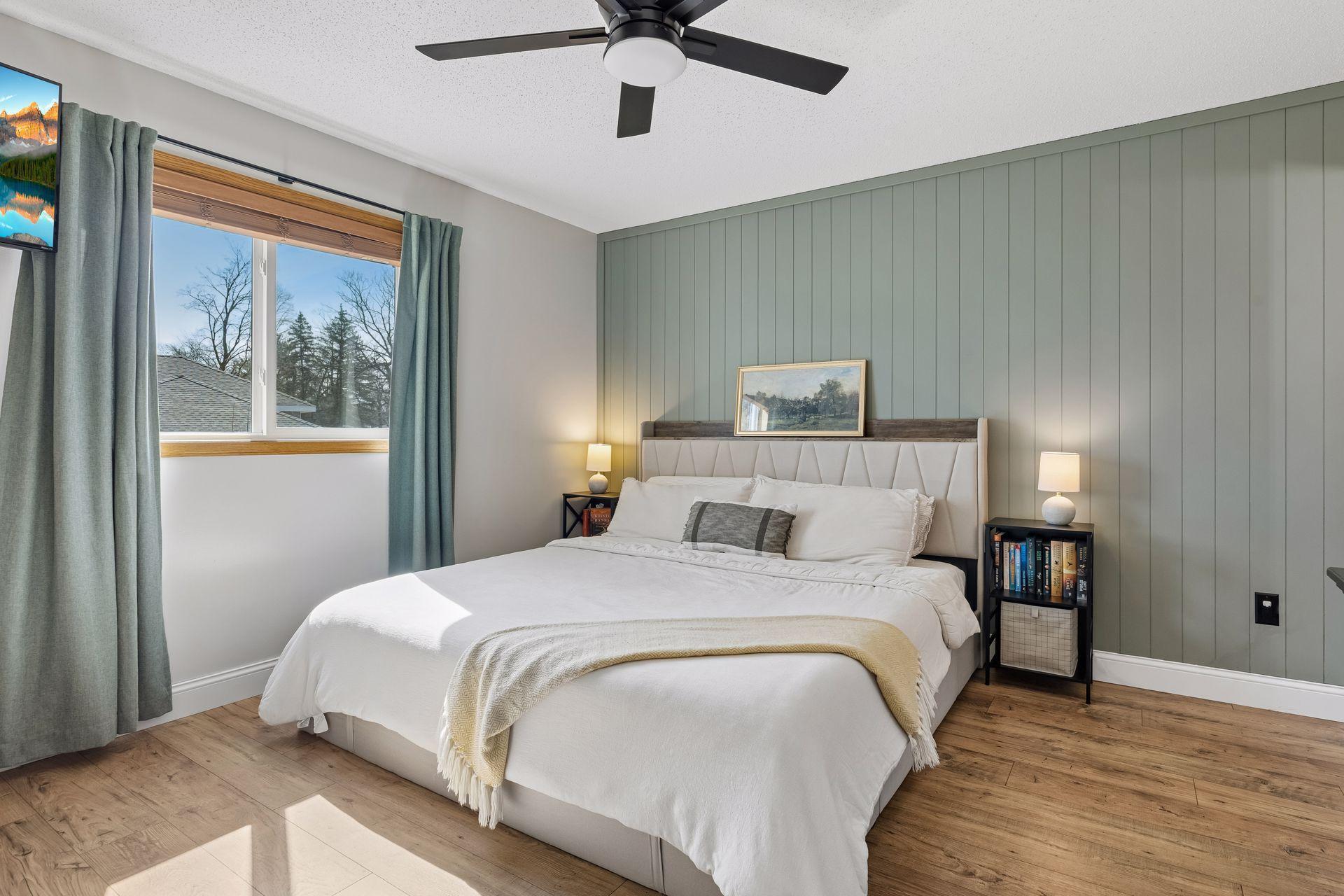 Large primary bedroom gets lots of natural light and has a gorgeous accent wall.
