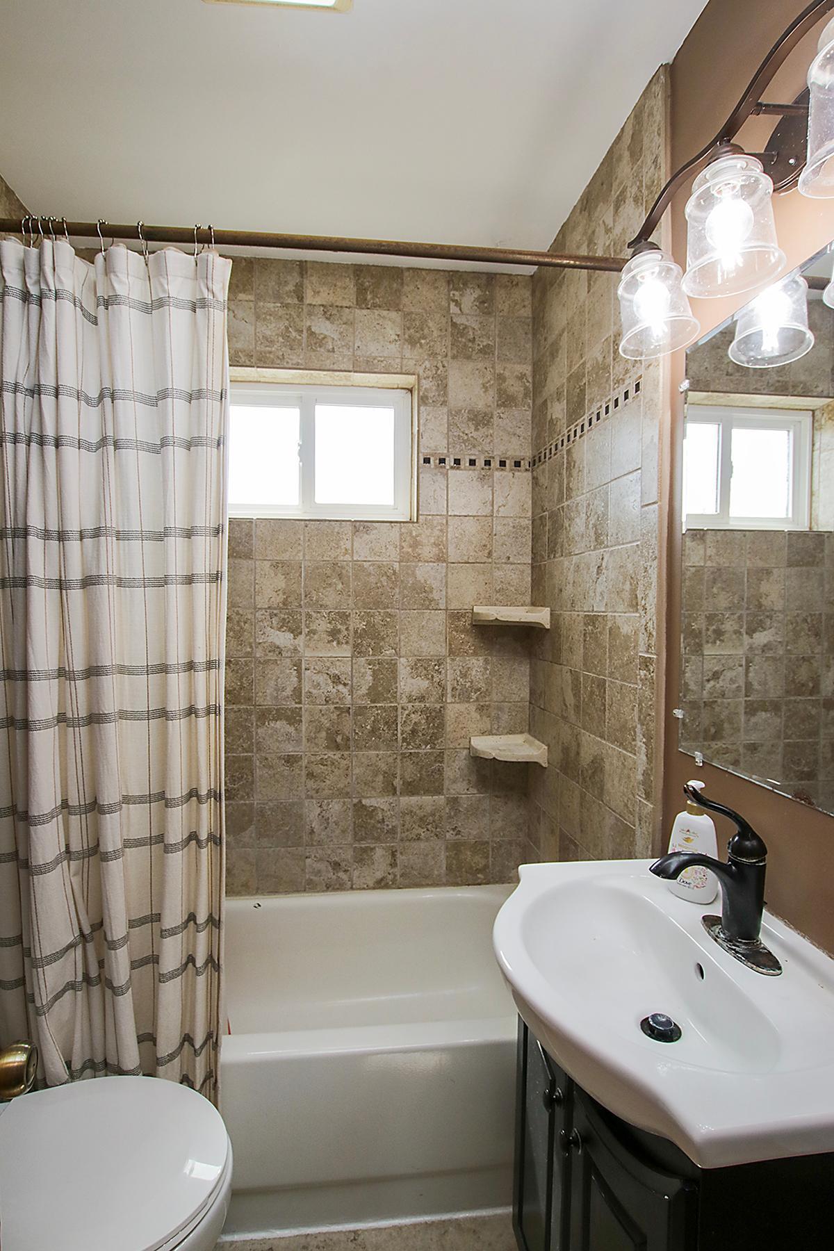 Fantastic tiled tub/shower in this refreshed main floor bathroom!