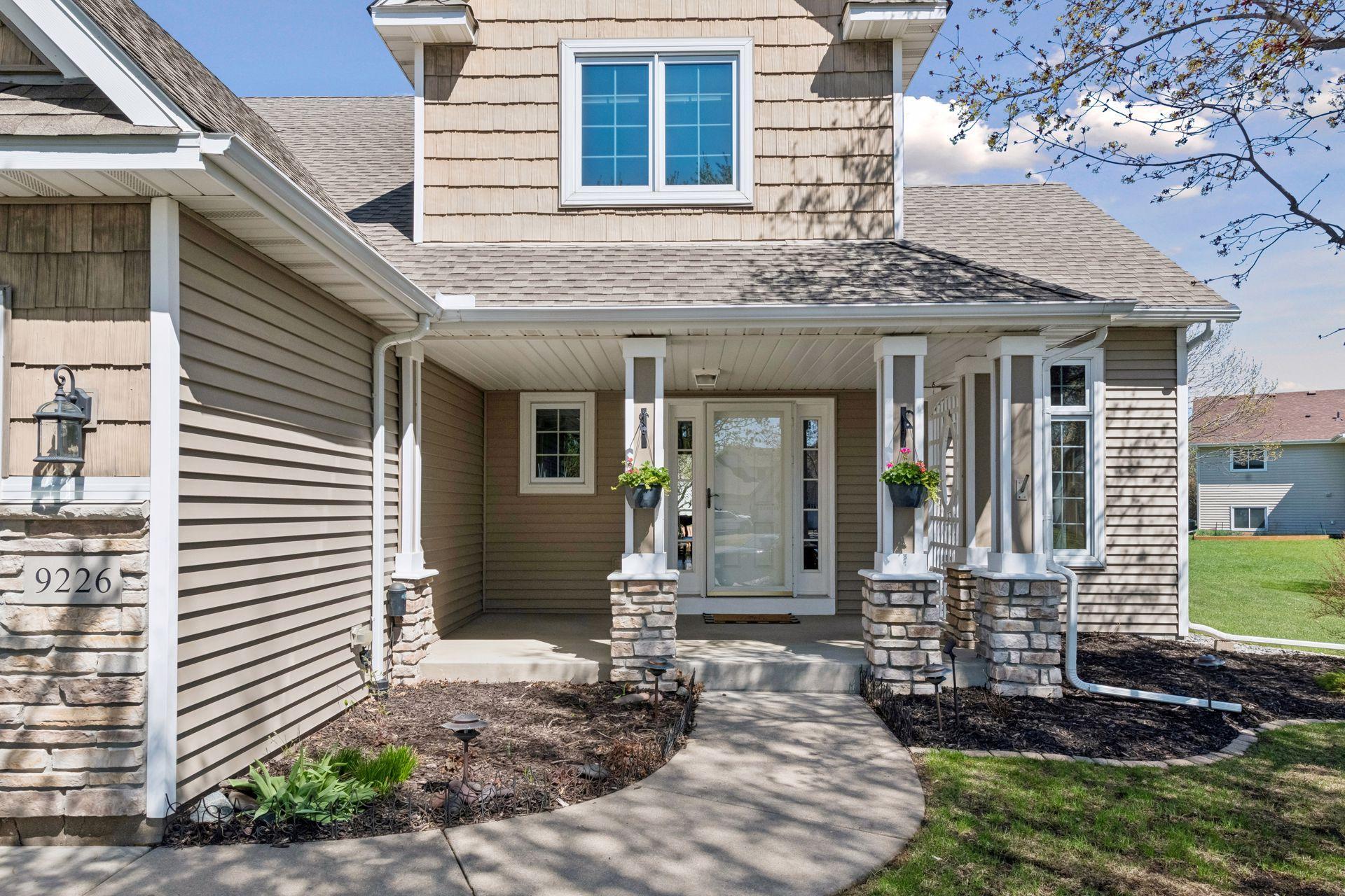 Welcoming porch framed by beautiful perennial gardens—perfect for greeting friends and family.