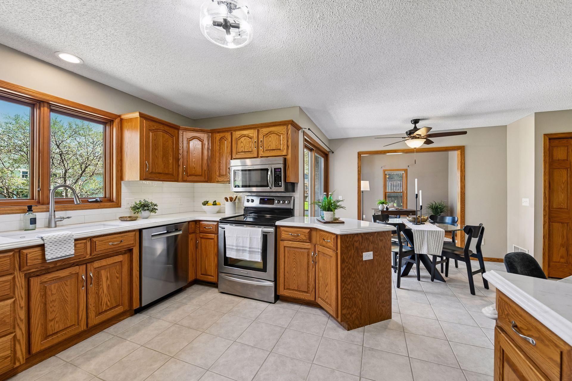 Kitchen opens to an informal dining area with ceiling fan and Light, ceramic tile flooring, and direct access to the outdoors. Enjoy the paver patio, deck, pergola and fire pit.