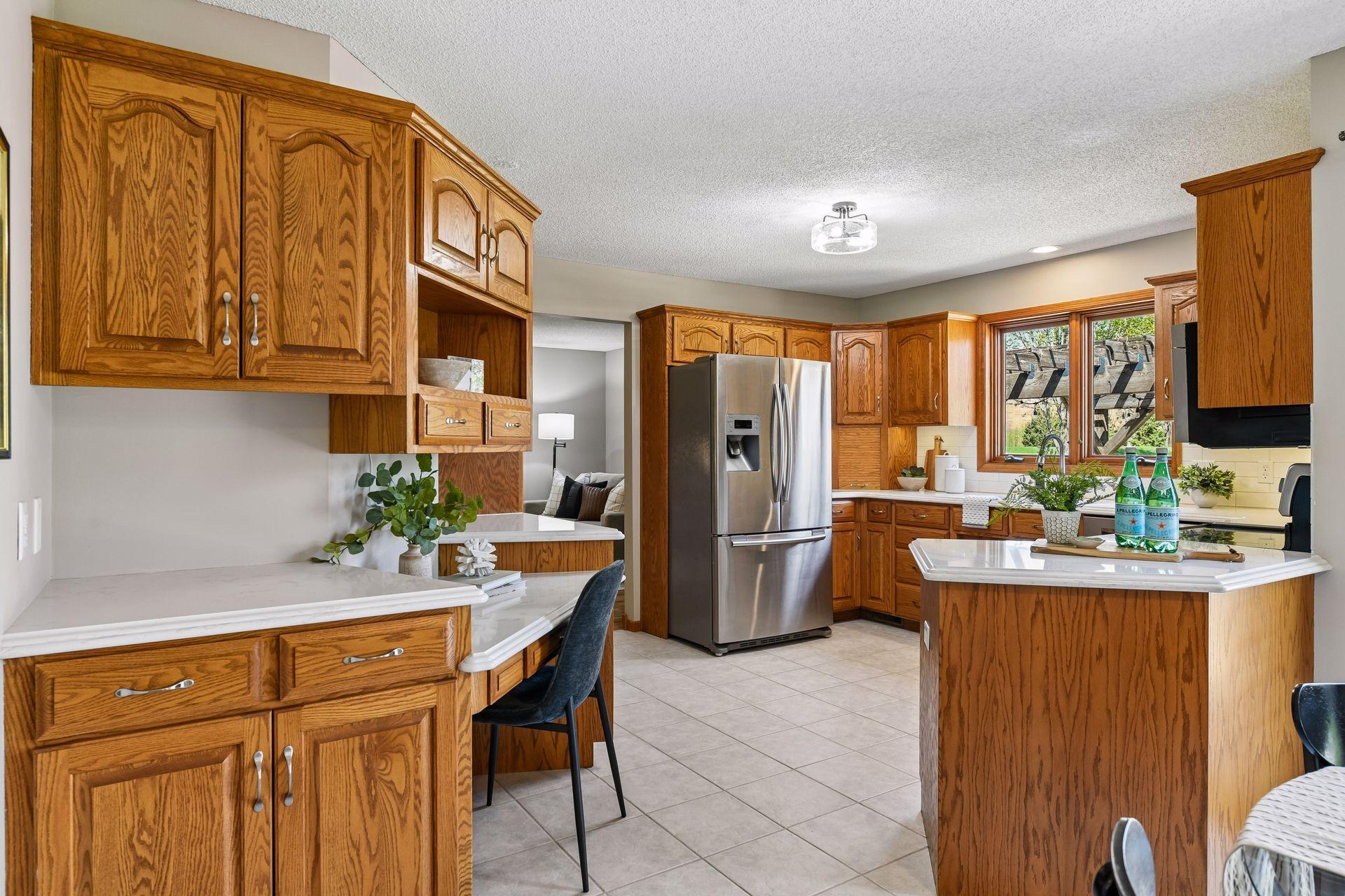 Beautifully appointed kitchen featuring stainless steel appliances, abundant storage, & Cambria countertops with bullnose edges. Enjoy lovely backyard views right from the kitchen, creating a bright & inviting space for everyday living & entertaining