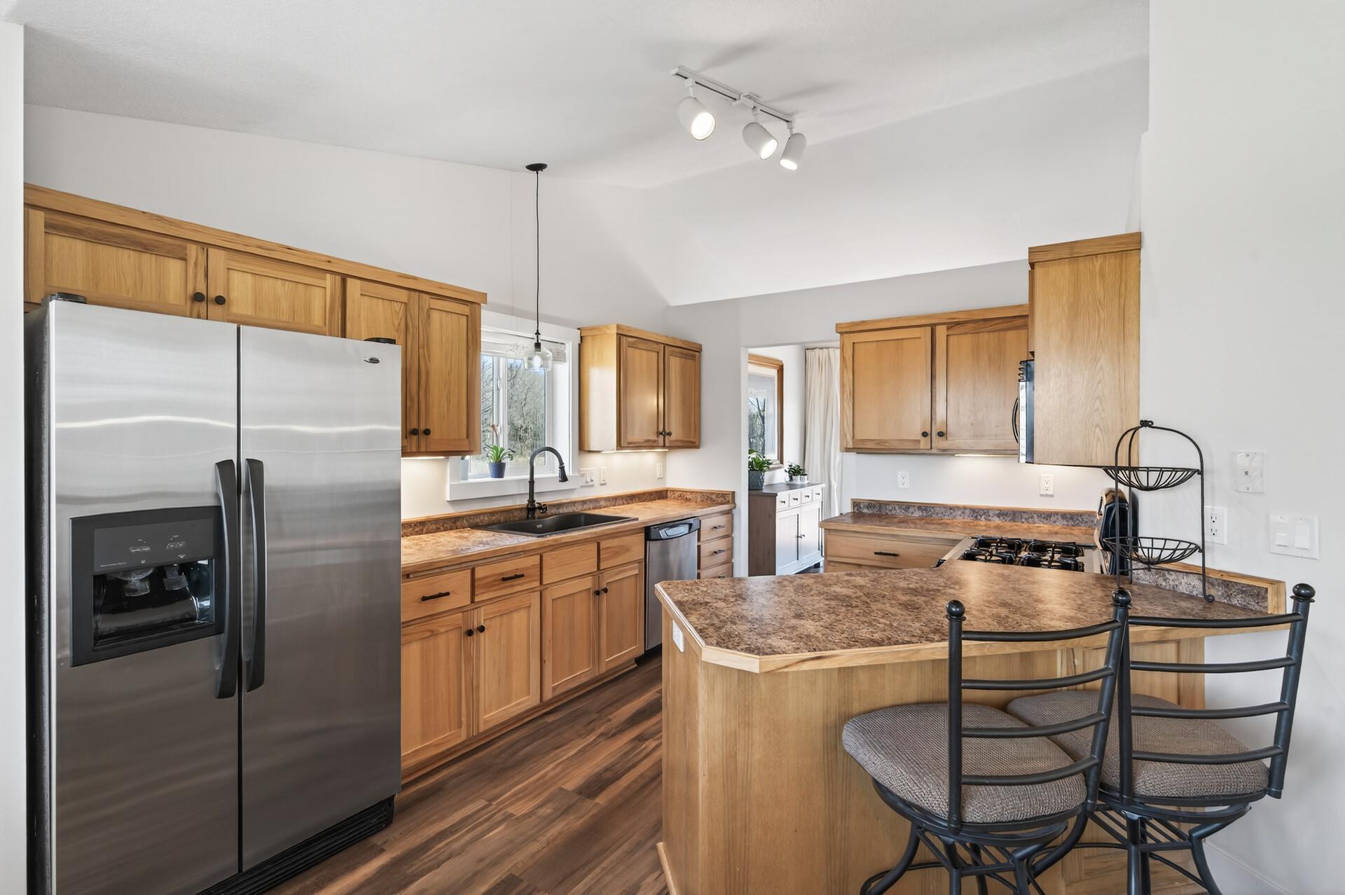 Upper level kitchen has stainless appliances including a gas range & new fixtures
