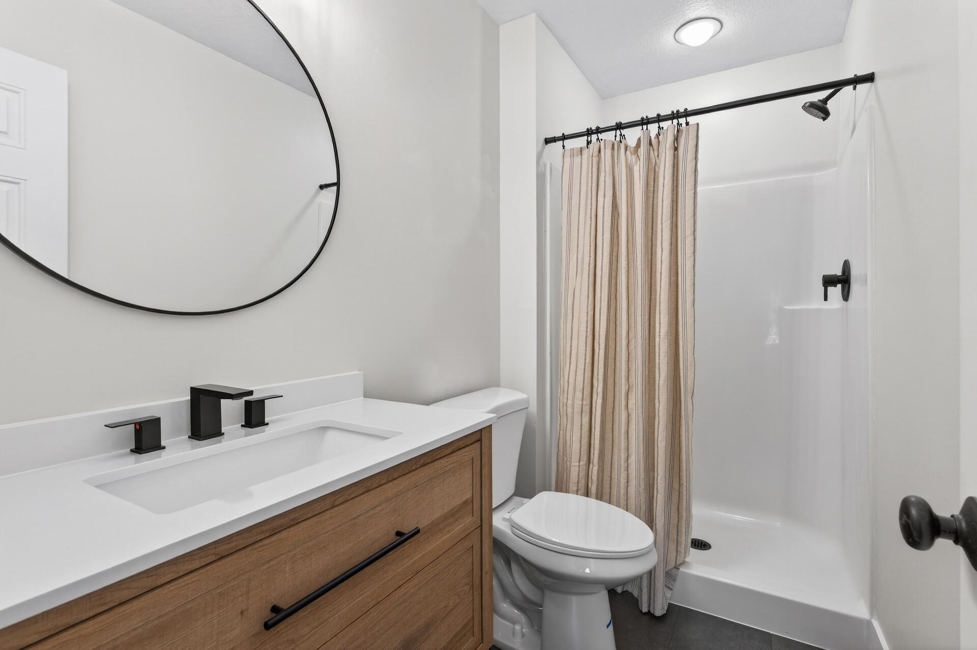 Primary three quarter bath with new LVP floor, vanity & fixtures