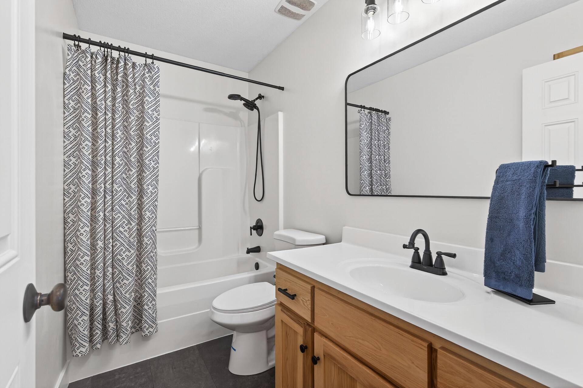 Upper level full hall bath with new LVP floor, counter top and fixtures. There's also a linen closet for storage.