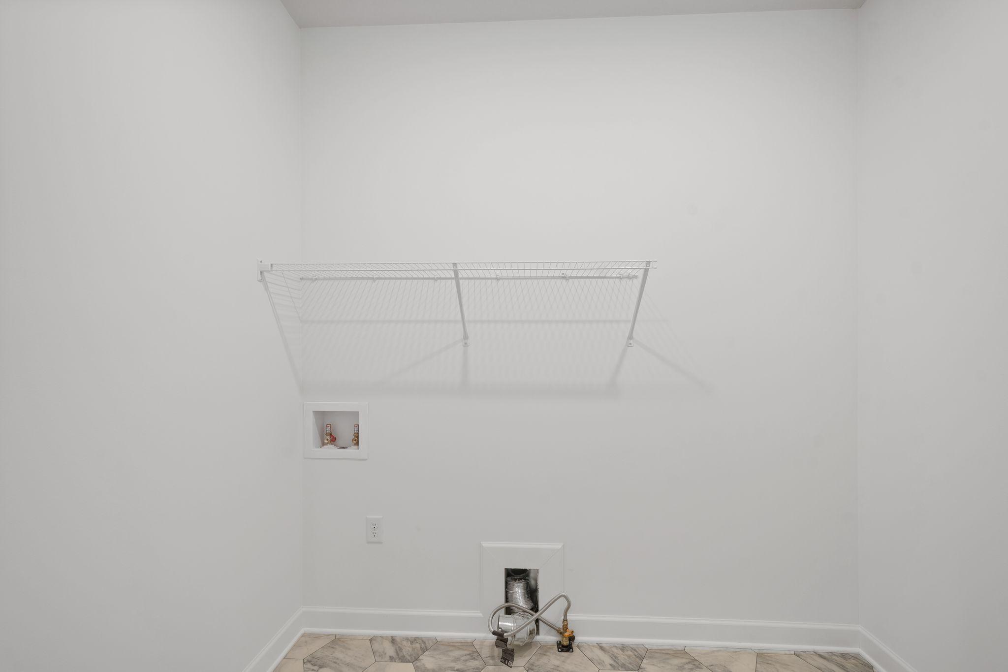 With ventilated shelving and washer-dryer hookups, the laundry room helps keep the home tidy during busy chore days.