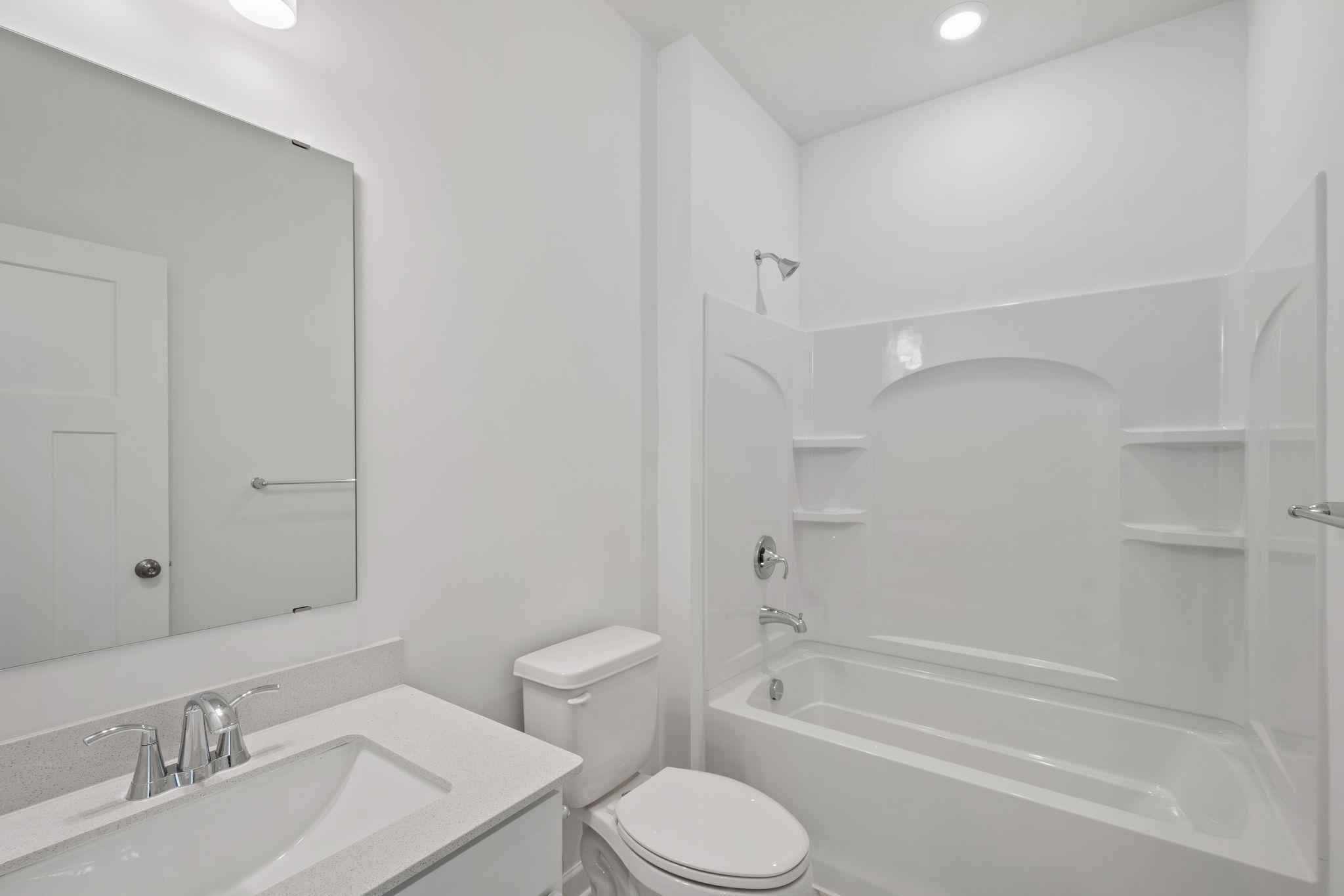 This full-sized bathroom is between the secondary bedrooms and features a single vanity and a shower-tub combination.