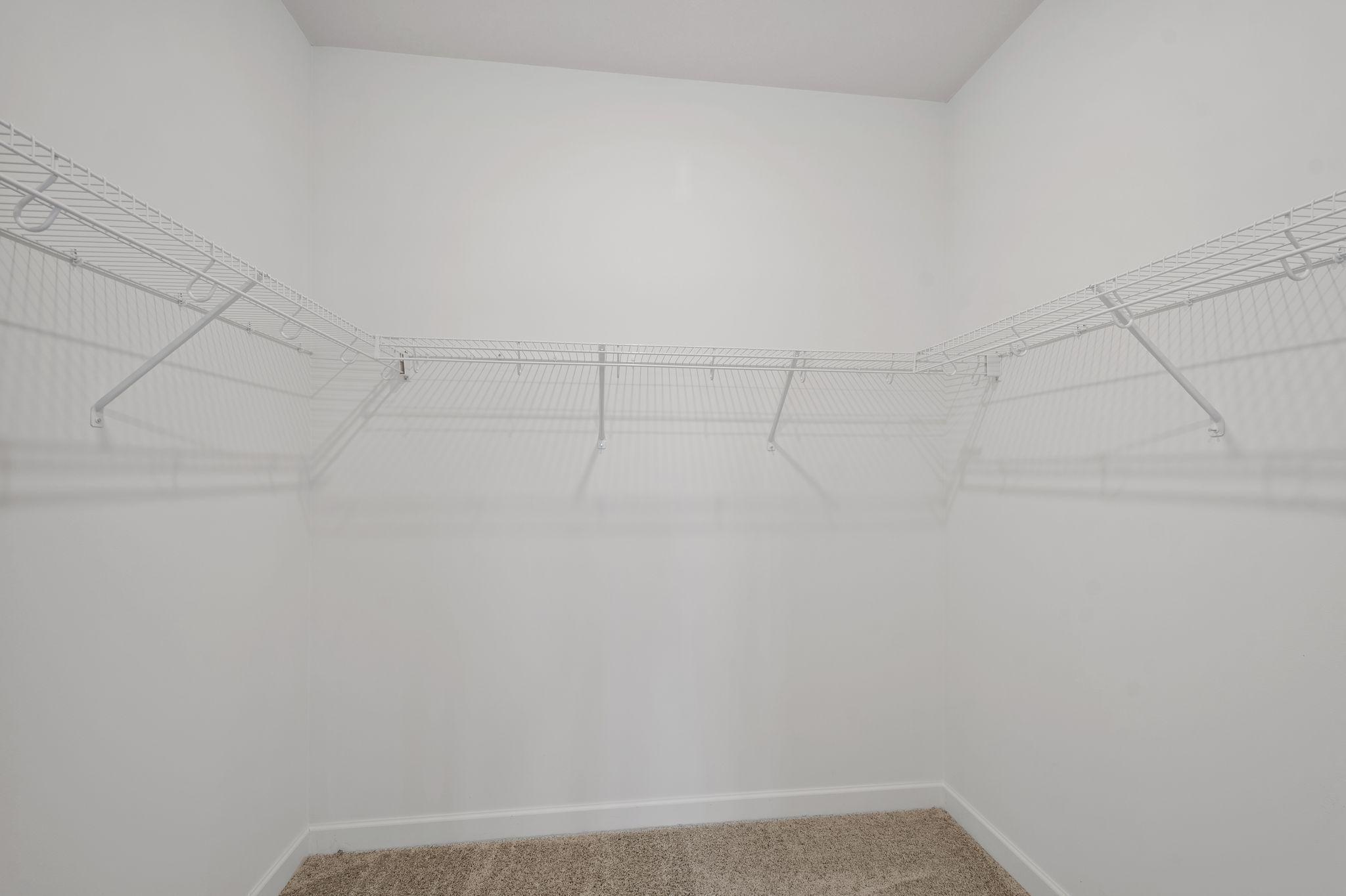 A mesh shelf in the walk-in closet provides wardrobe organization