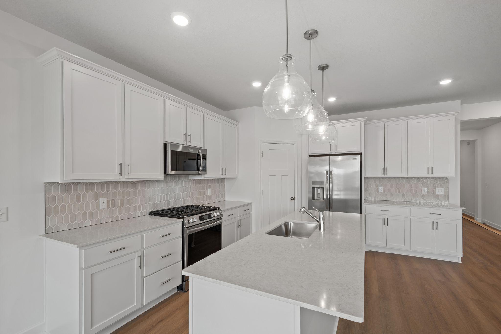 The kitchen features brand-new appliances, ample cabinetry, designer-selected countertops and a pantry for added storage space.
