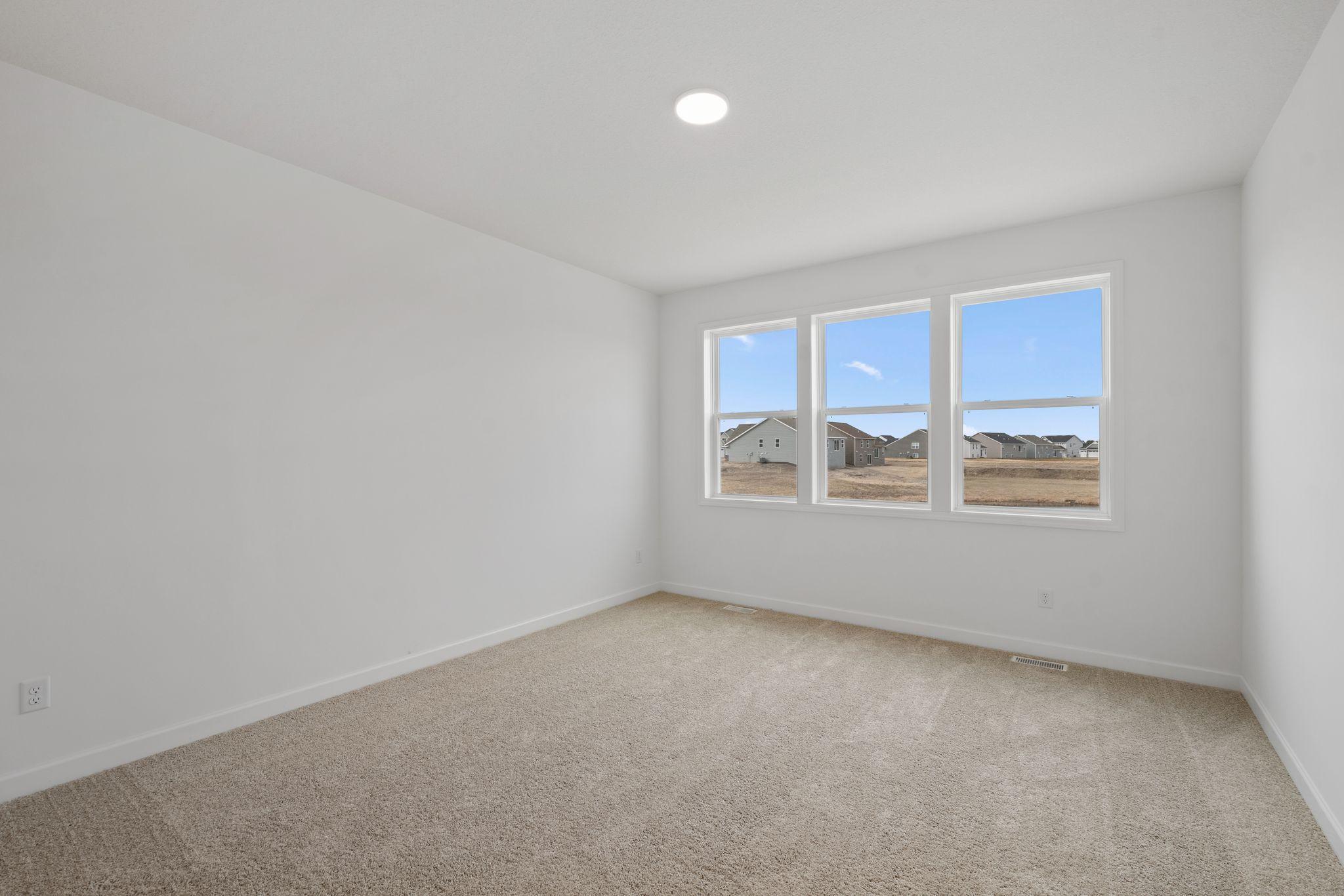 An owner’s suite sits in a rear corner of the home and is a relaxing oasis with an en-suite bathroom and walk-in closet.