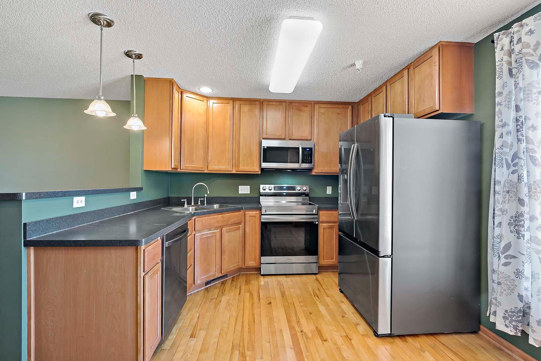 Look at the cabinet space! Newer (2024) SS appliances, hardwood floors and abundant countertop space makes this a gourmet chef's dream kitchen area.