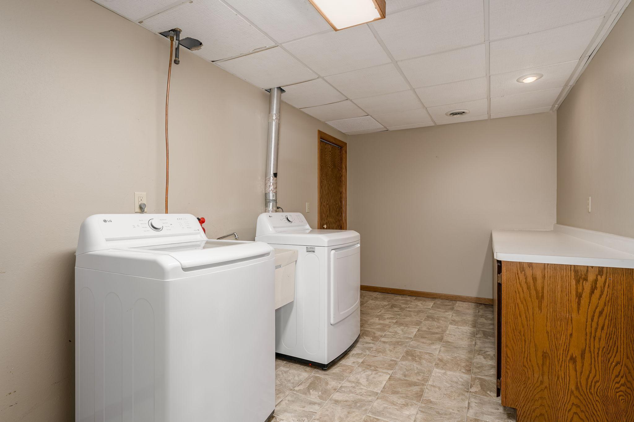 The laundry room, equipped with a newer washer and dryer (2023), offers ample space and could easily be converted into a convenient kitchenette.