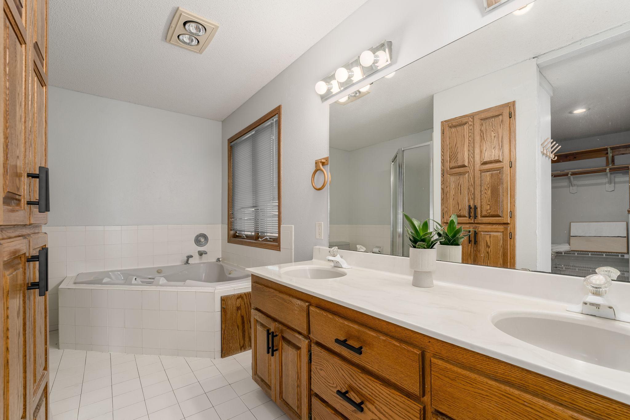 The primary bath offers a spa-like retreat, complete with a double vanity, a separate soaking tub, and a spacious walk-in shower for ultimate relaxation and convenience.