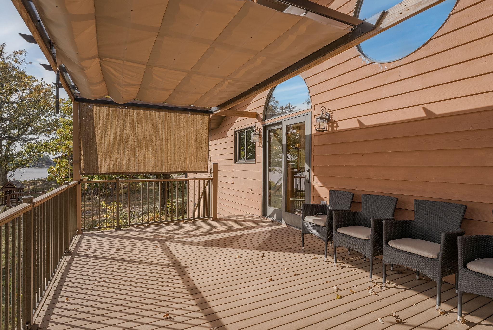 The home features a massive, maintenance-free deck equipped with a retractable awning canopy, offering a perfect space for outdoor relaxation and entertaining.