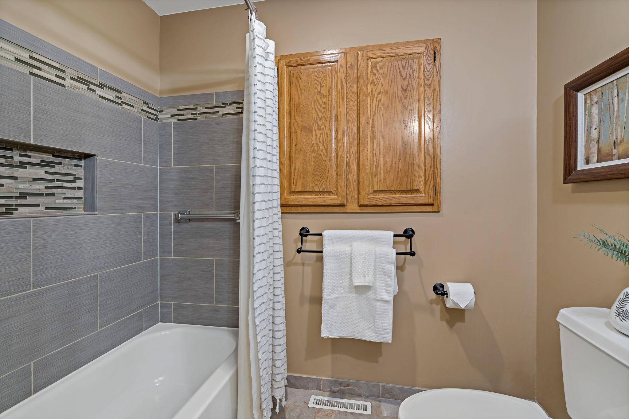 Stunning custom tile work takes center stage in this beautifully appointed upper-level bath.