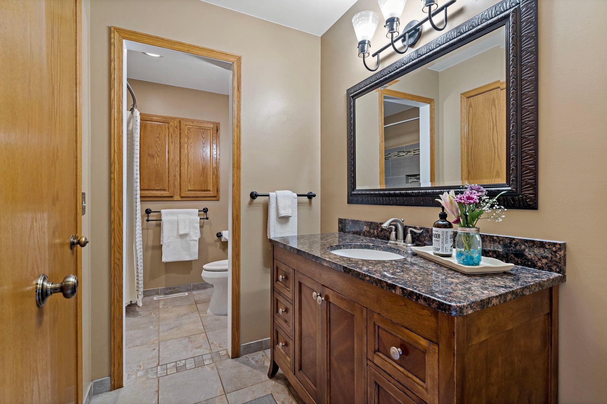Upper level bathroom has a walk through to the primary bedroom and has fantastic tile work throughout.