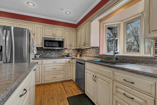 Stainless steel appliances, recessed lighting, tiled backsplash and a double oven.