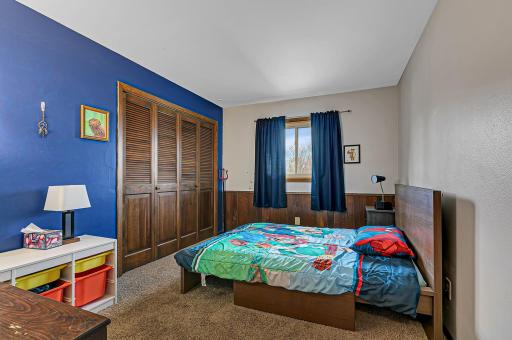 Upper level bedroom with double closet and carpet flooring.