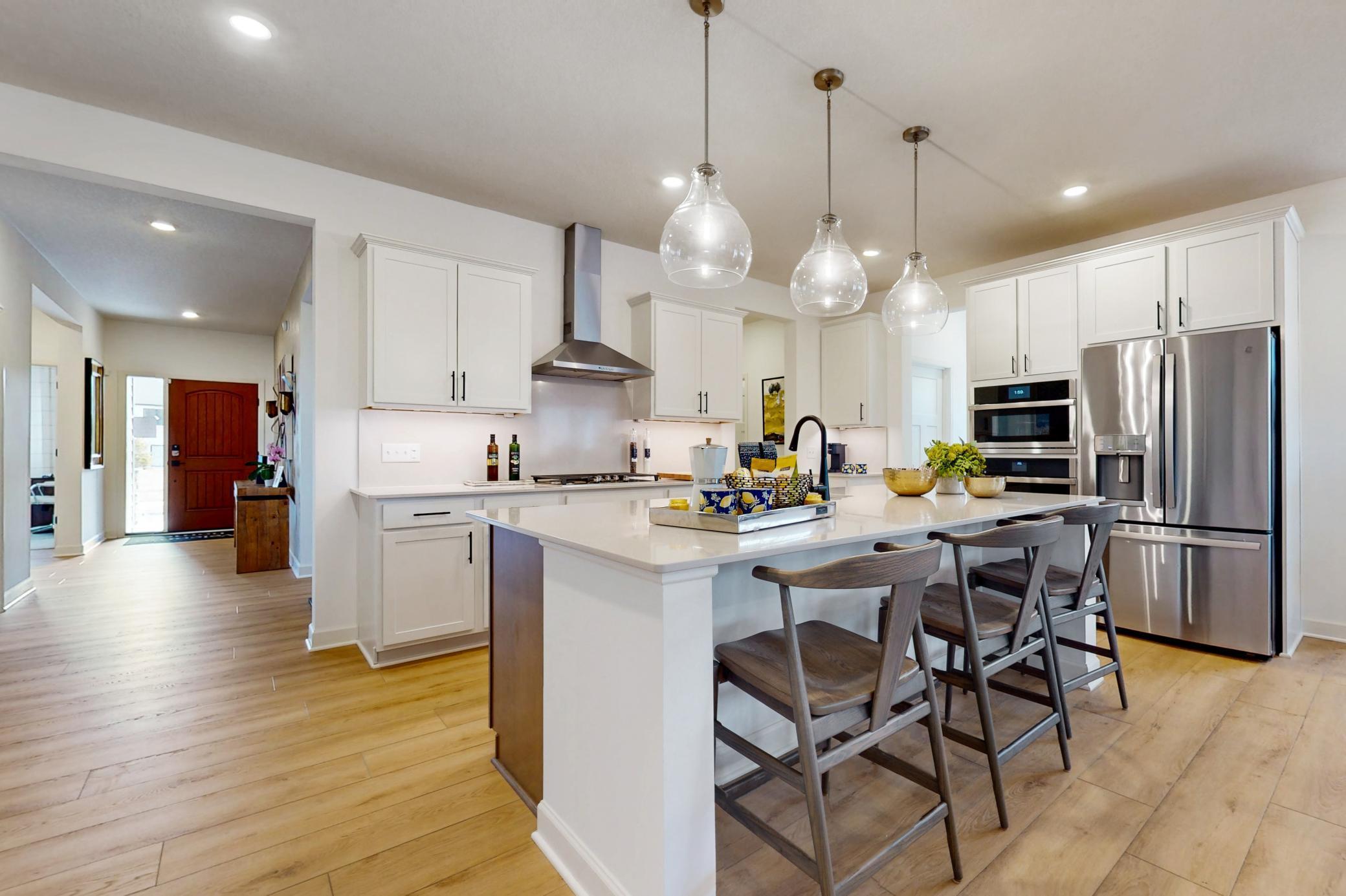 (Photo of a similar home, actual home's finishes will vary slightly) Welcome to the Birmingham! This spacious gourmet kitchen features a large center island, quartz countertops, under undermount sink, LVP wood floors, and stainless steel appliances.