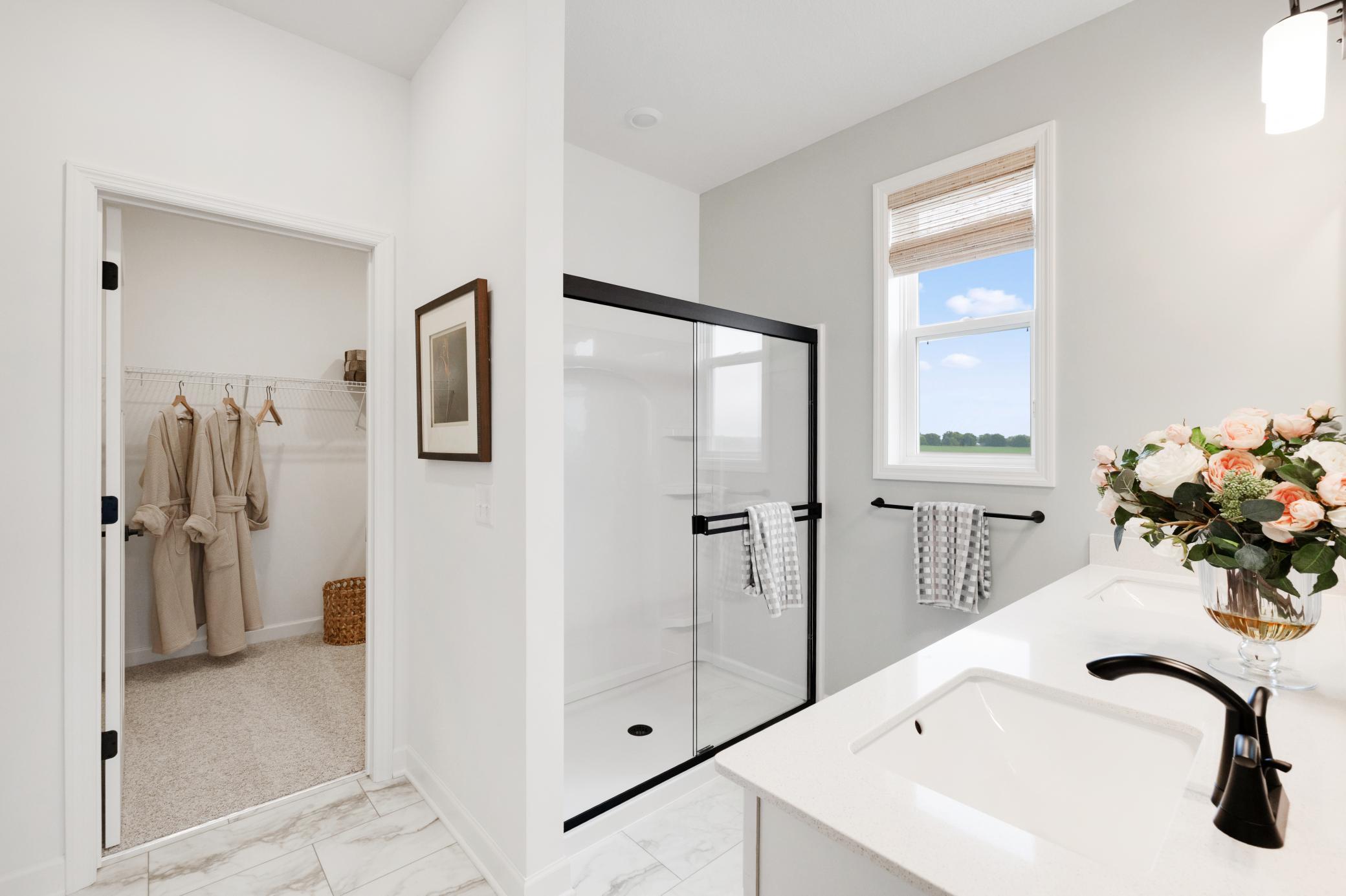 (Photo of a similar home, actual home's finishes will vary slightly) An extension of the primary suite, this private and spacious bath contains a double-vanity and shower.