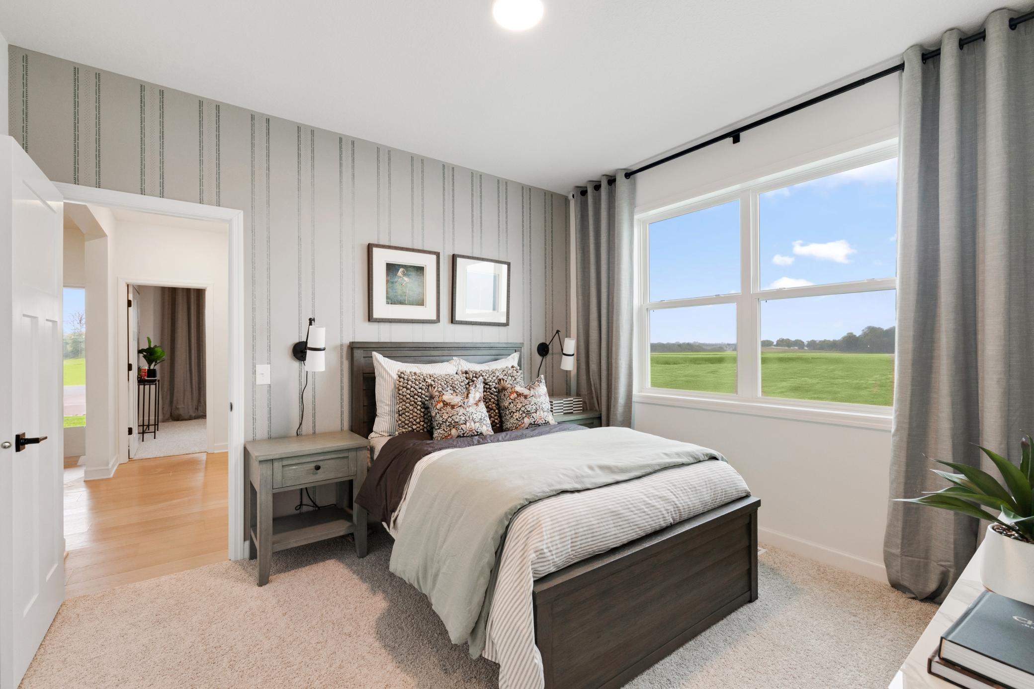 (Photo of a similar home, actual home's finishes will vary slightly) Main level secondary bedroom.