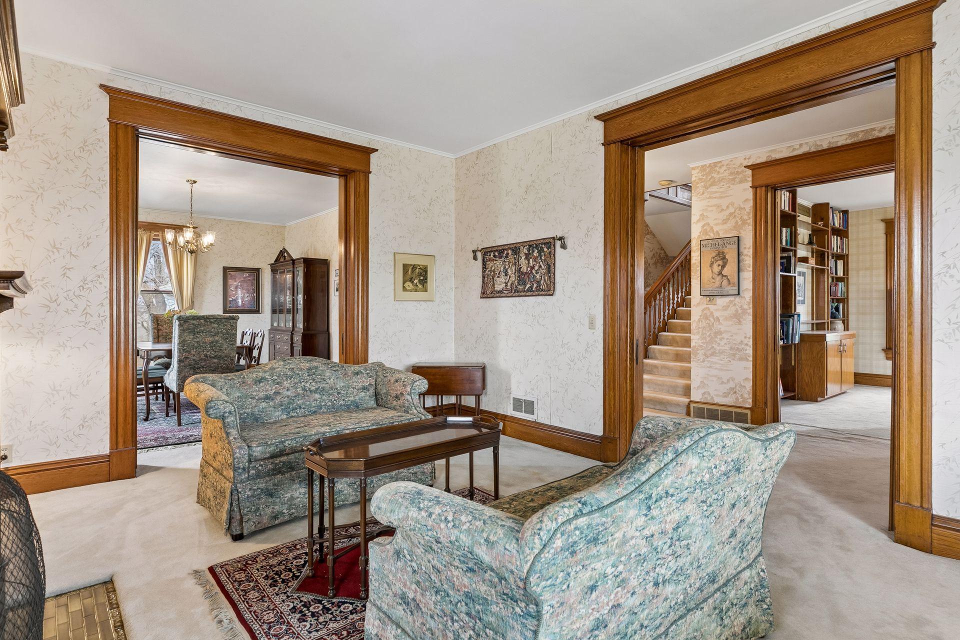 Showcasing the meticulous woodwork with pocket doors and inlaid hardwood floors under the carpeting