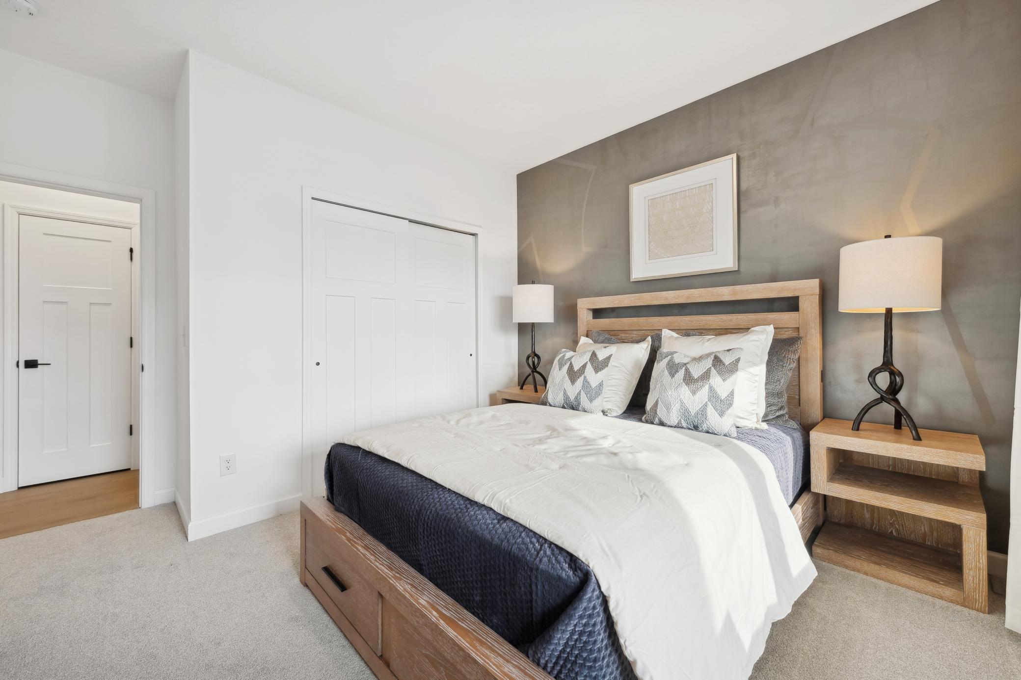 (Photo of decorated model, actual home's finishes will vary) The main level bedroom.