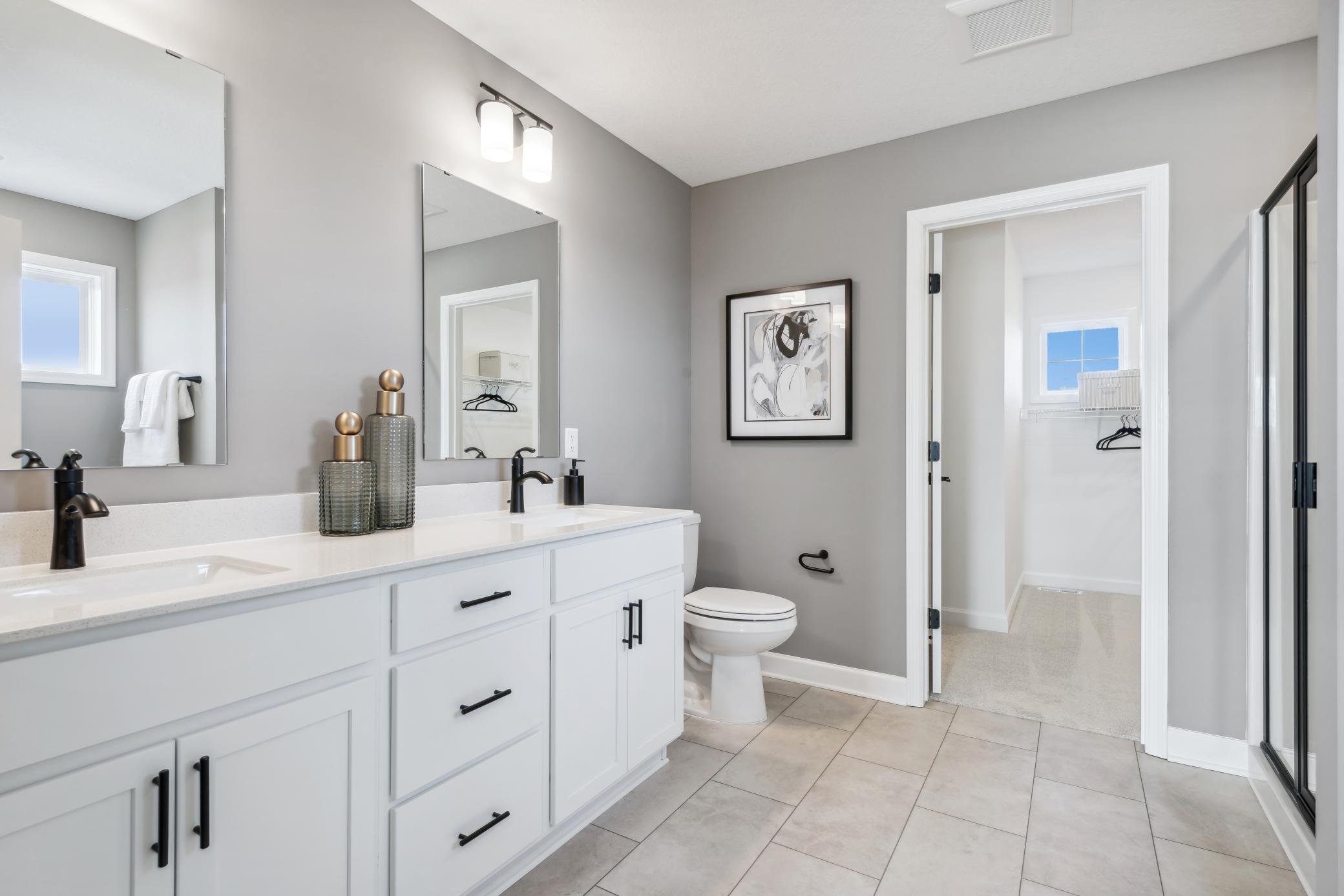 (Photo of decorated model, actual home's finishes will vary) An extension of the primary bedroom, this private and spacious bath contains a double-vanity, a soaking tub and a separate shower.