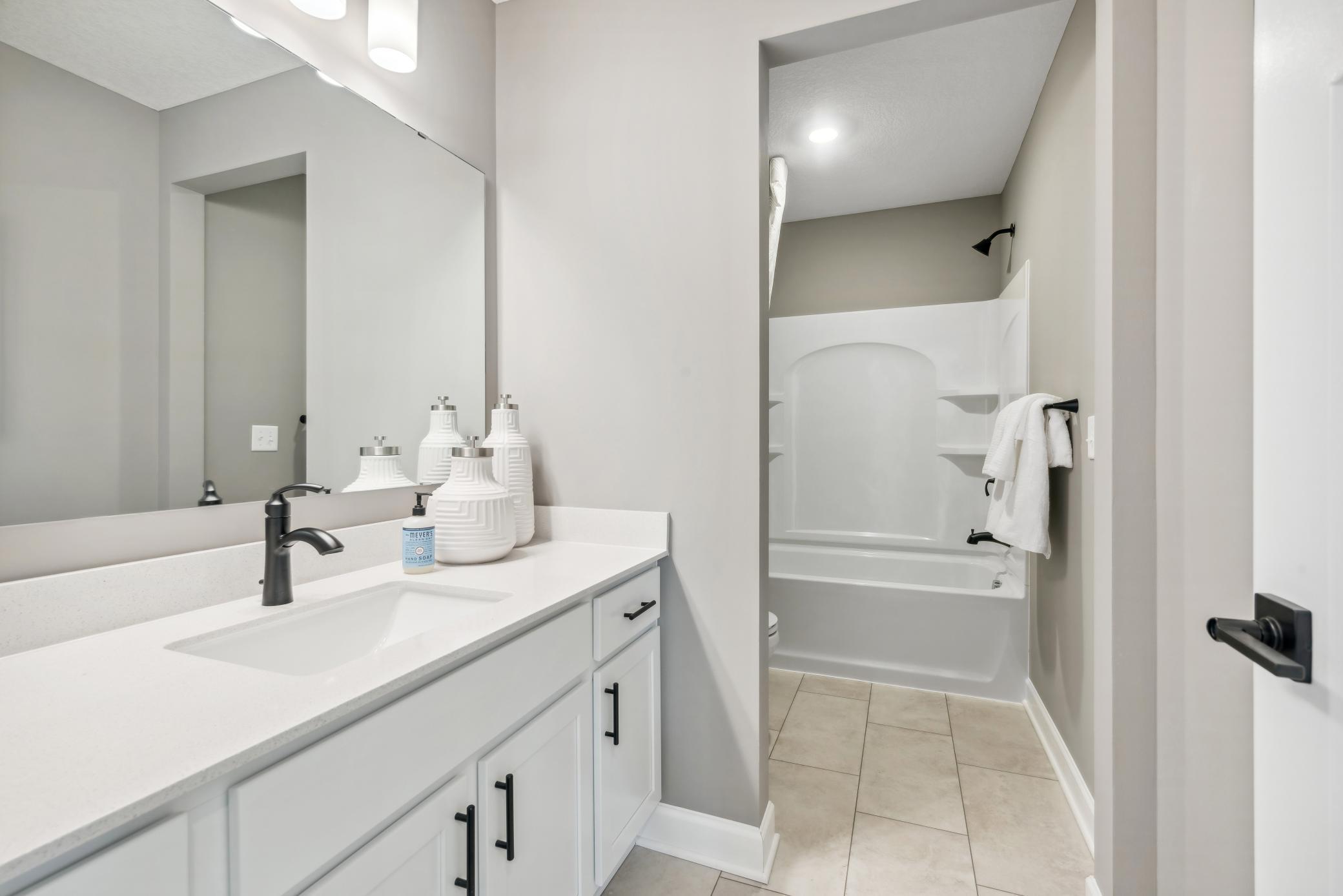 (Photo of decorated model, actual home's finishes will vary) Featuring a double-vanity, this secondary bath is sure to keep everyone moving during those busy mornings.