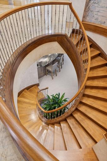 Beautiful walnut staircase leading to the lower level from foyer. Second staircase near the kitchen,
