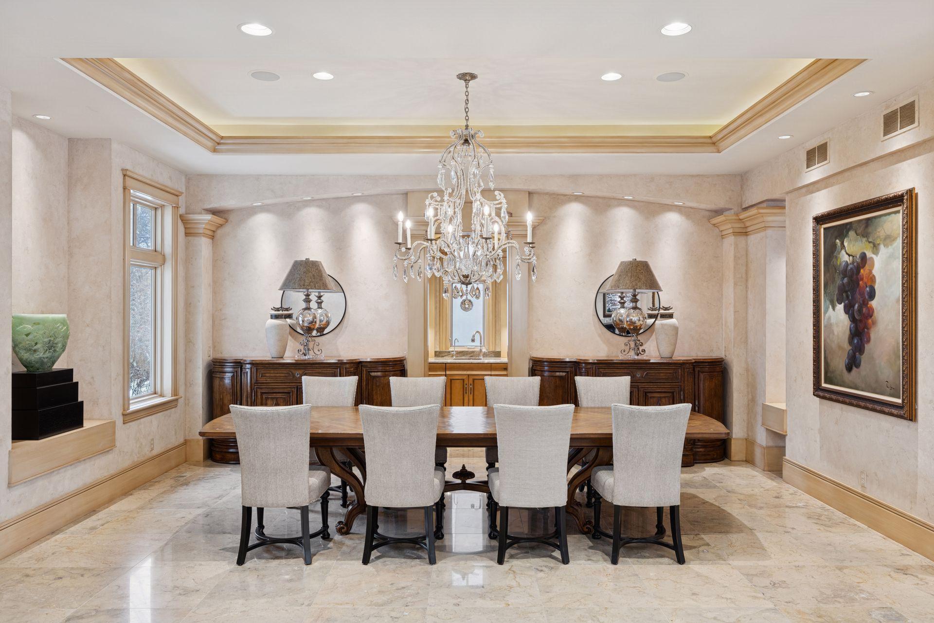 Crystal chandelier over a dining table that can easily seat a party of twelve. Set a softer mood with the soffit and recessed lights.