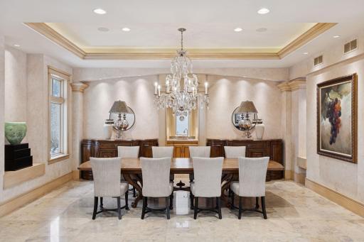 Crystal chandelier over a dining table that can easily seat a party of twelve. Set a softer mood with the soffit and recessed lights.