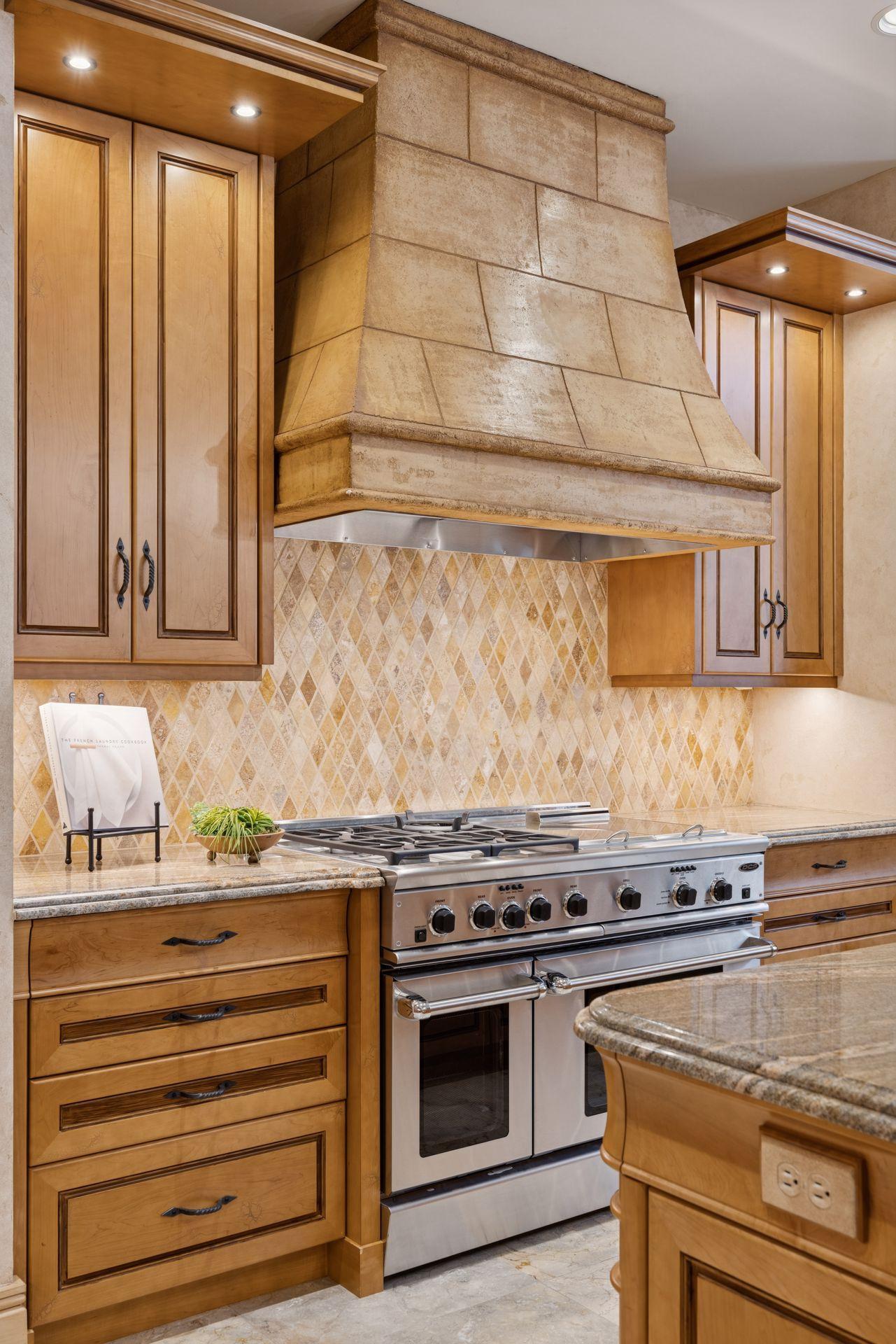 Stylish hood vent enhances the beautiful contrast between the tile and cabinetry.