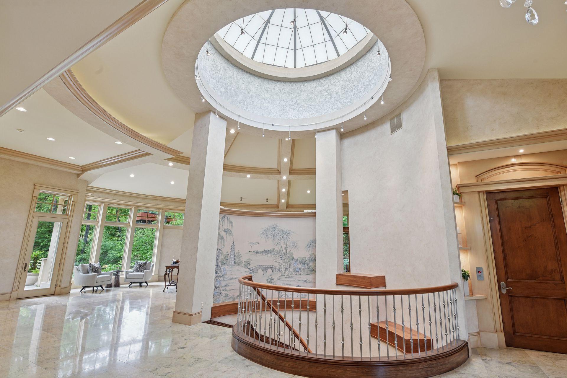 Gorgeous marble floors, softly lit by the natural light from glass cupola over curved wood staircase.