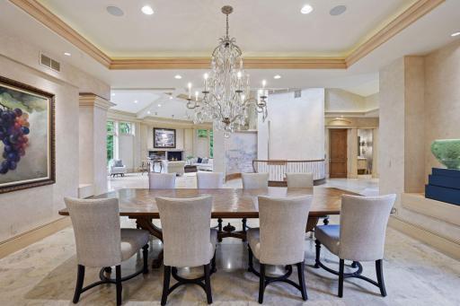Beautiful formal dining room with an amazing chandelier, crown molding with recessed lighting in cove.